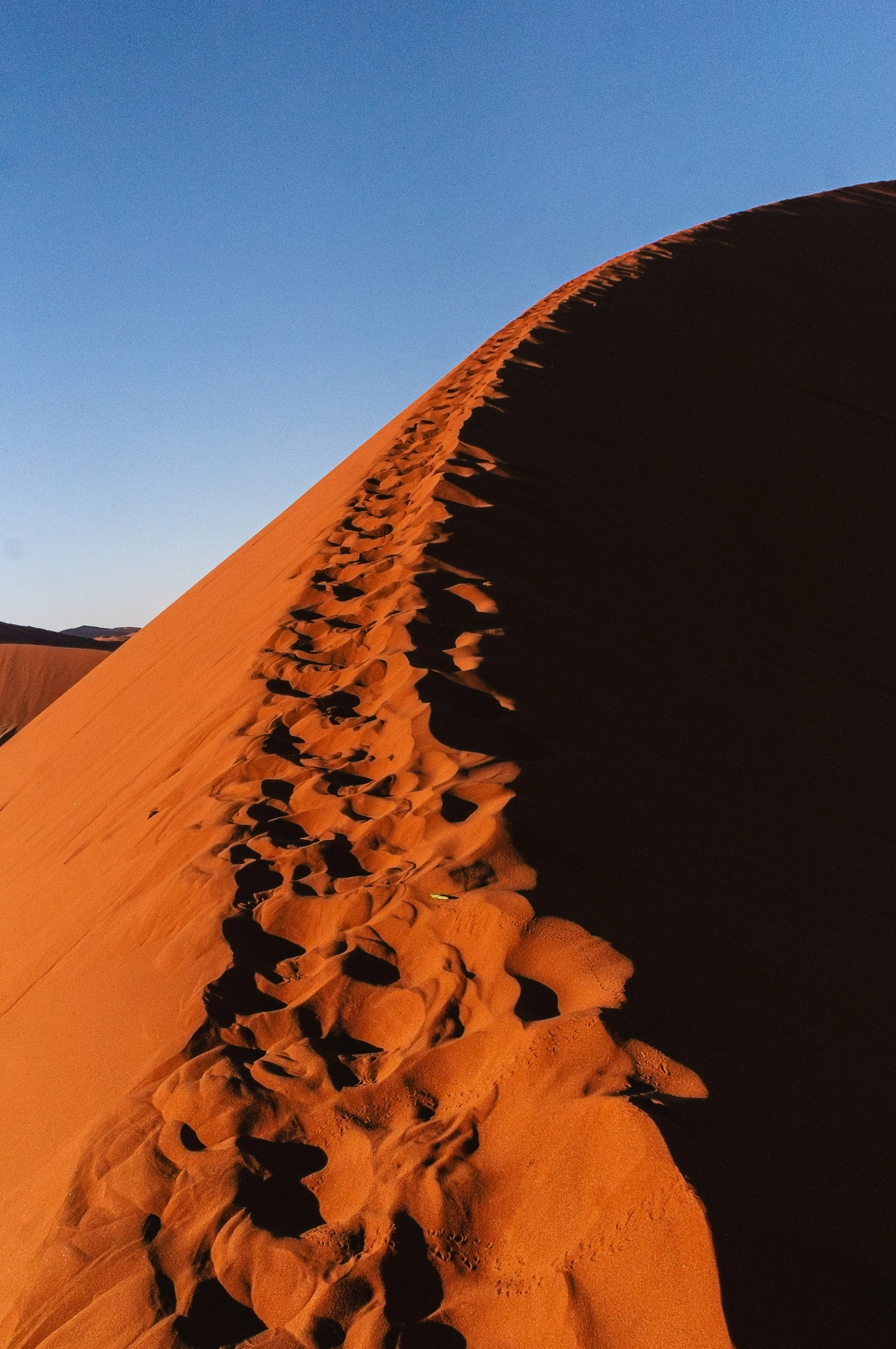 a long trail of sand leading to the top of a desert