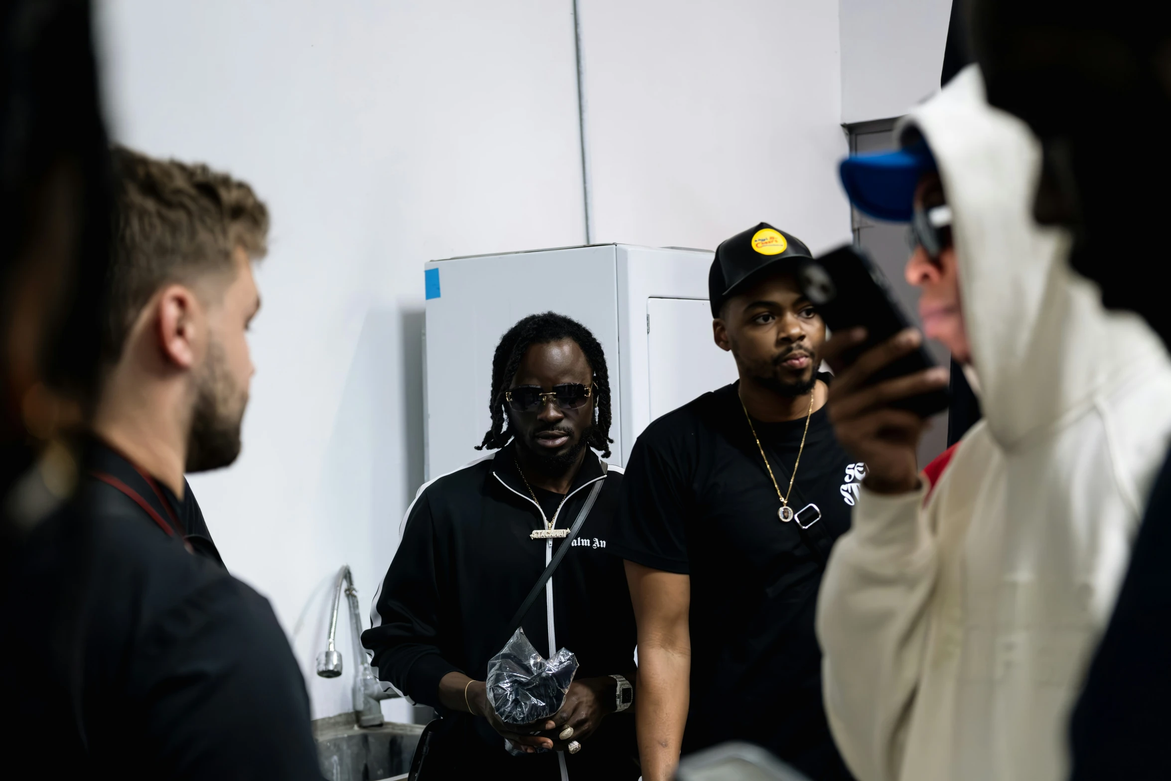 a group of people standing in front of a mirror with phones