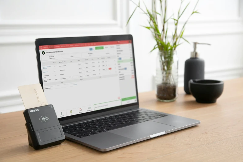 the keyboard on the table is next to a cellphone and laptop