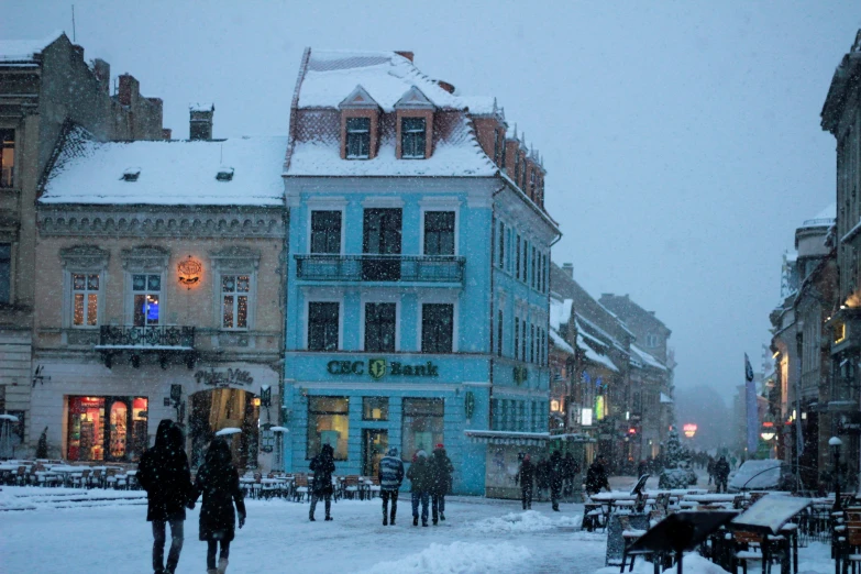 a snow filled street with people walking through it