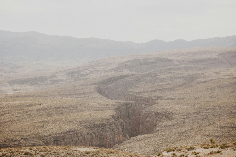 a view of some mountains, and a person walking on the hill