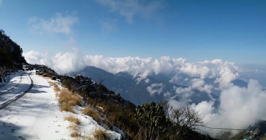 the view over the mountains shows clouds and grass