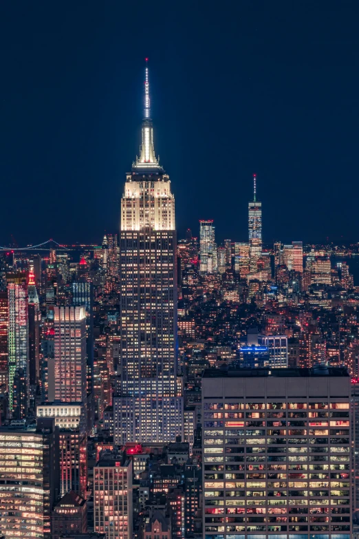 view of large buildings at night with the empire building in the distance