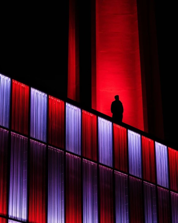 a man standing on a roof next to a red and blue wall