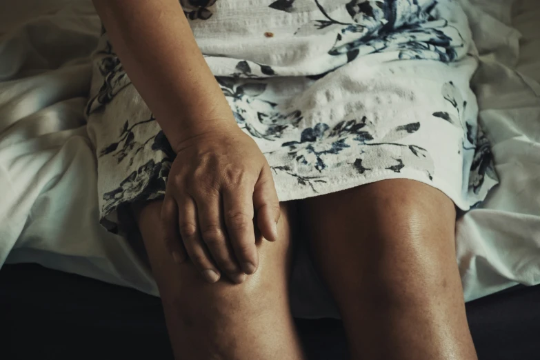 a woman wearing no shoes sitting on a bed