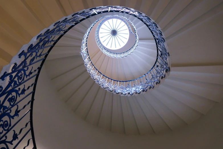 a very large round staircase with a white ceiling