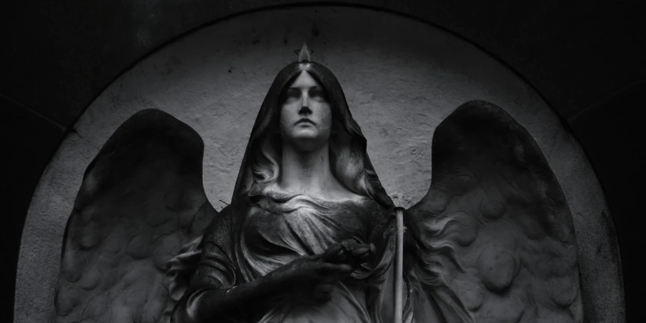 a woman is holding a sword in front of an angel statue