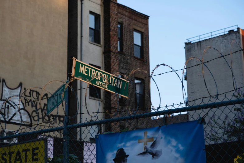 several signs hang from the barbwires of several buildings