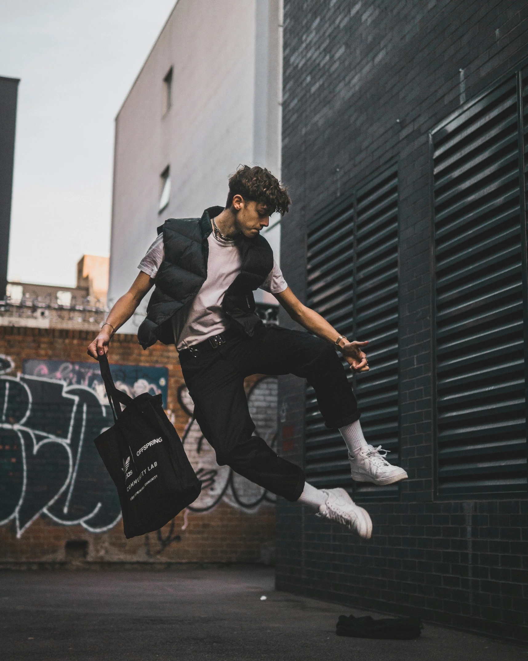 a man jumping up in the air with his handbag