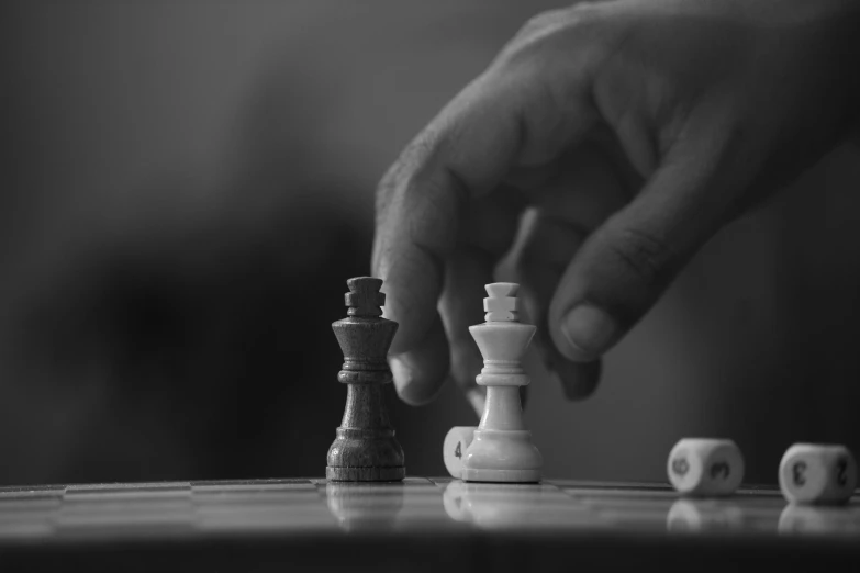 a hand is pointing at the pieces of a chess set