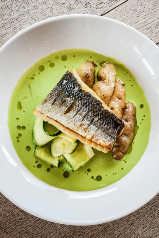 a white bowl of food sits on a wooden table