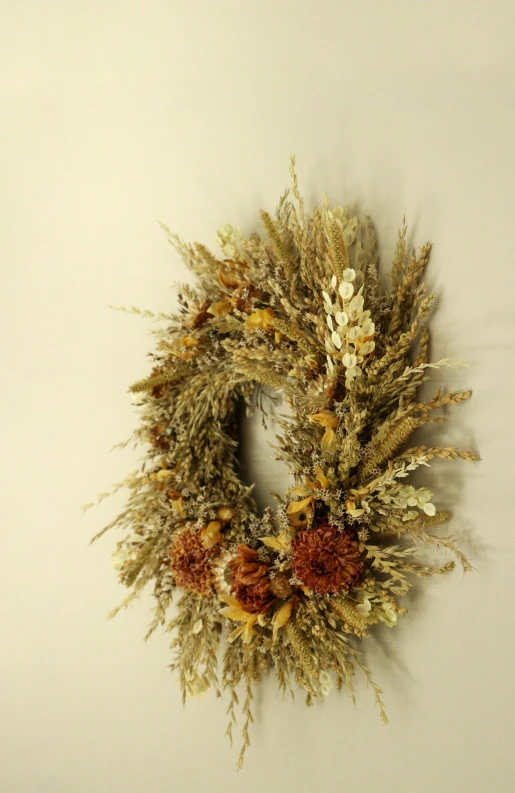 the dried wreath hanging on the wall has been decorated with orange flowers