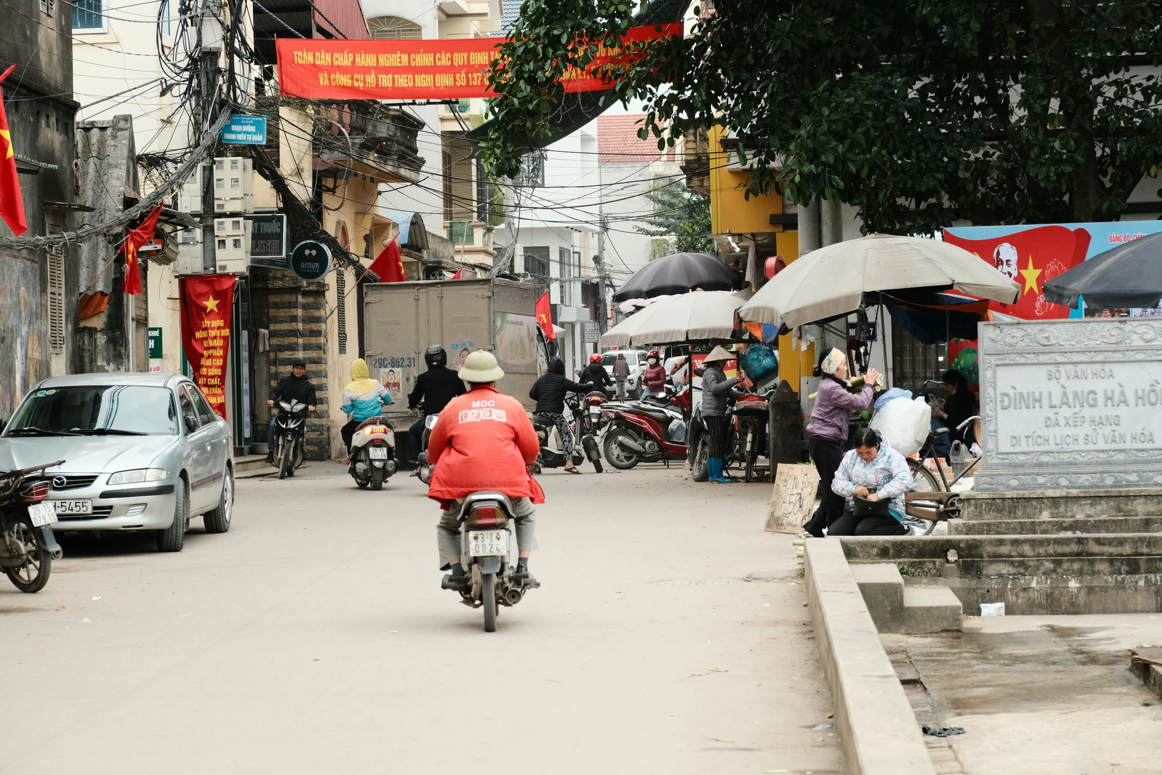 a person rides a motorcycle down the narrow street