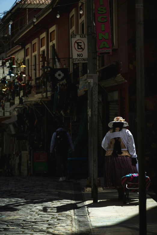 a person walking down the sidewalk near several buildings