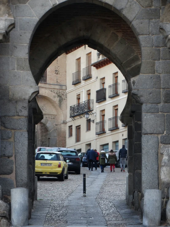 a group of people walking towards a large arch