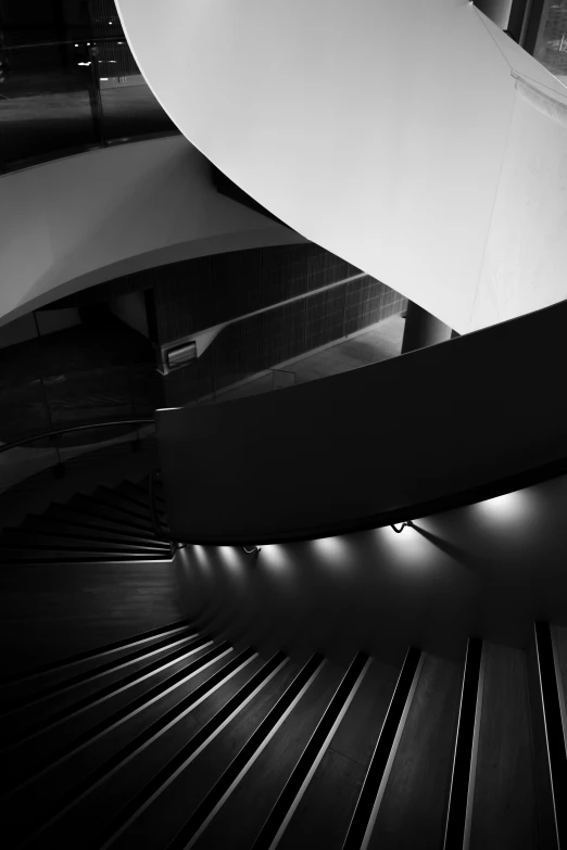 a stair - railing in the center of a building with lights in it