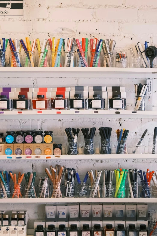 several white shelves of various assorted colored pens