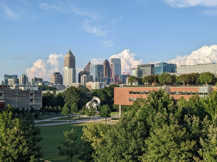 a cityscape is in the distance surrounded by trees and a park