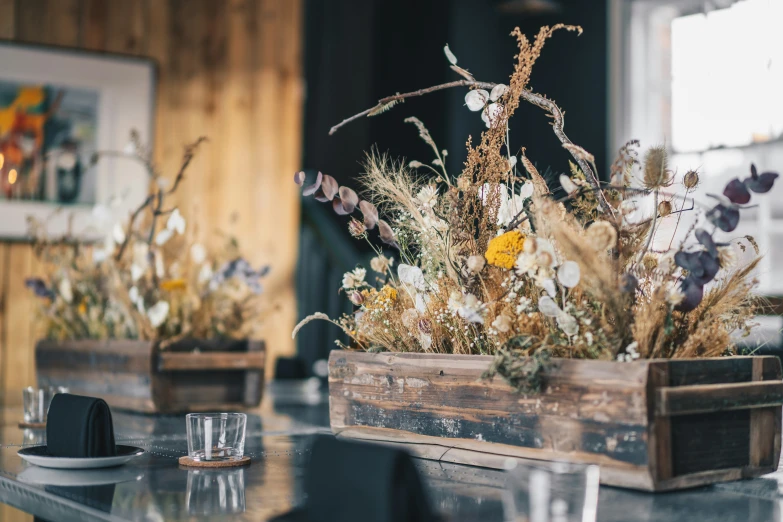 flowers are displayed in crates at a table