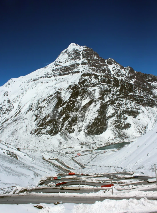 a snow covered mountain and road with vehicles