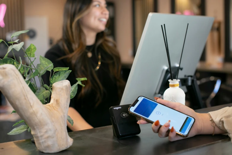 a woman at a counter in an office checking her phone