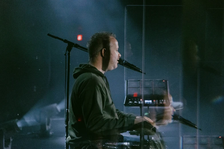 there is a man with a keyboard in front of microphone