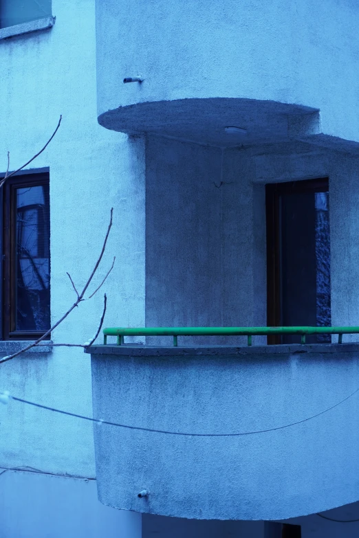 a balcony with windows and green rails