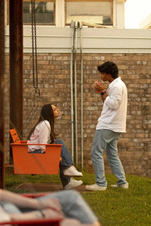 the two people are standing by the bench outside