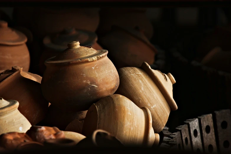 pottery pots and other items sit together in the dark