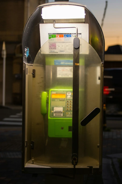 an old pay phone with the cover closed and the light on