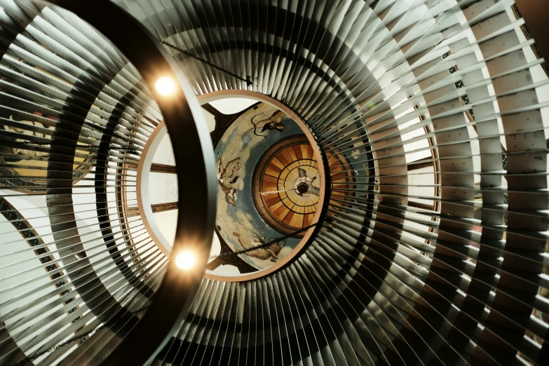 the spiral staircase has many round objects mounted on it