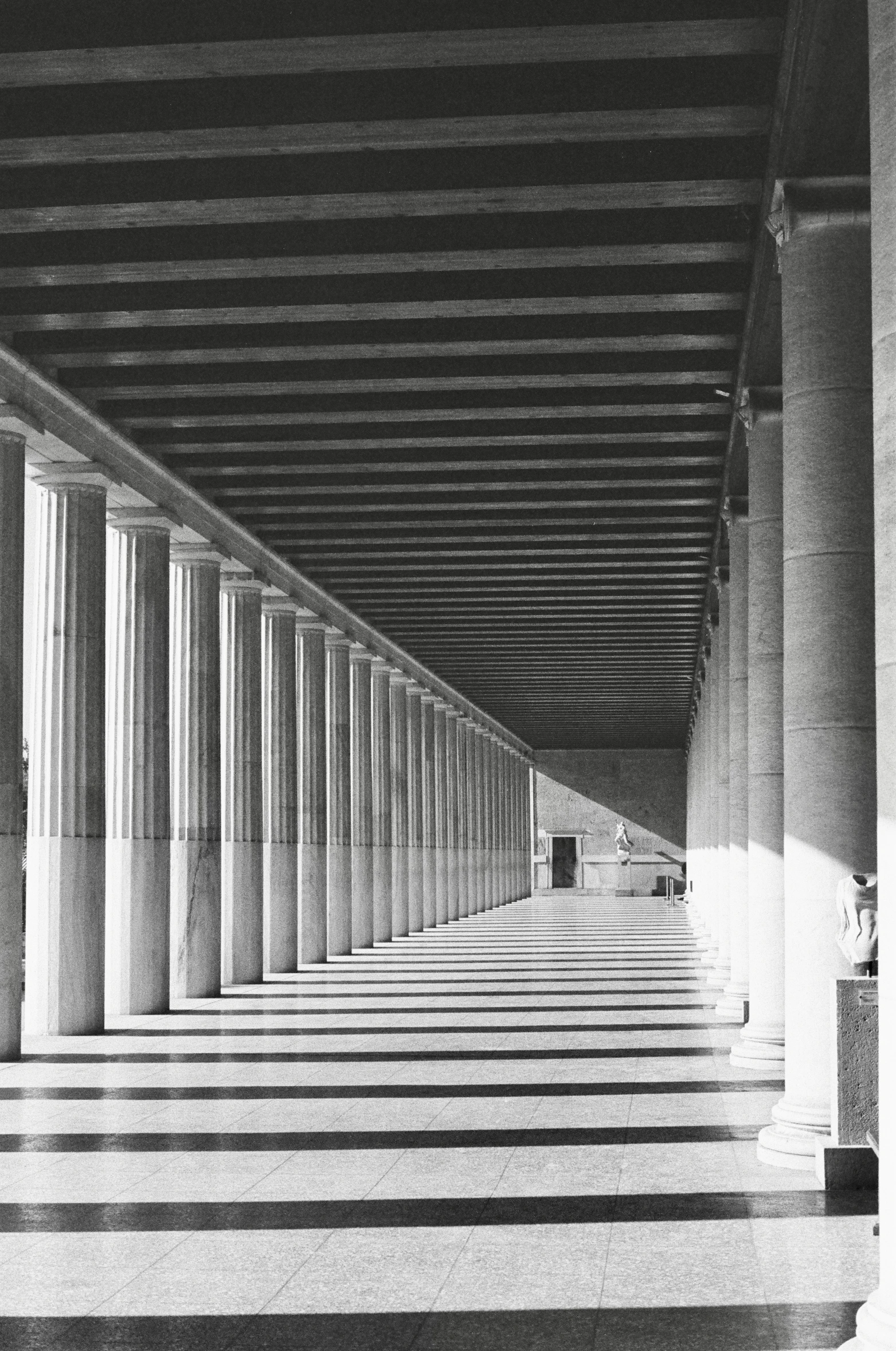 a long line of white columns with one person in the center