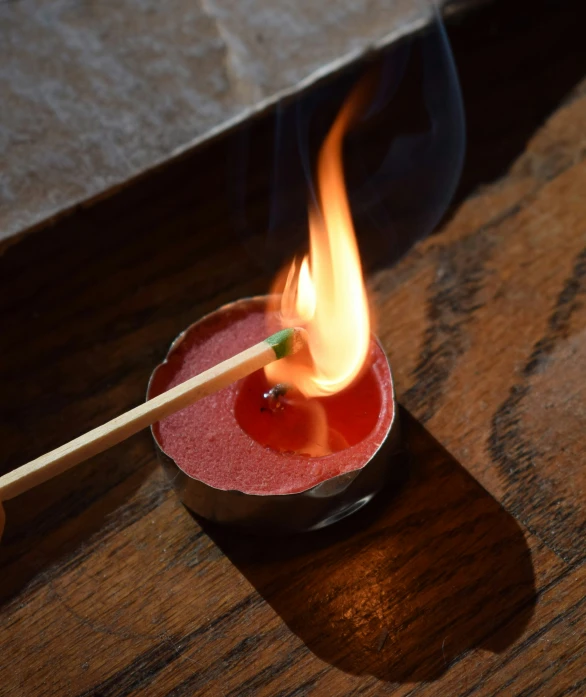 red drink with blue smoke is sitting on the wooden table