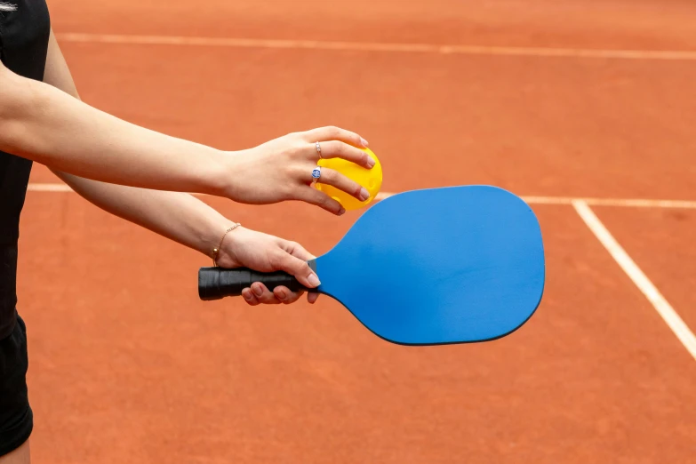 a woman holding a table tennis racket and ball