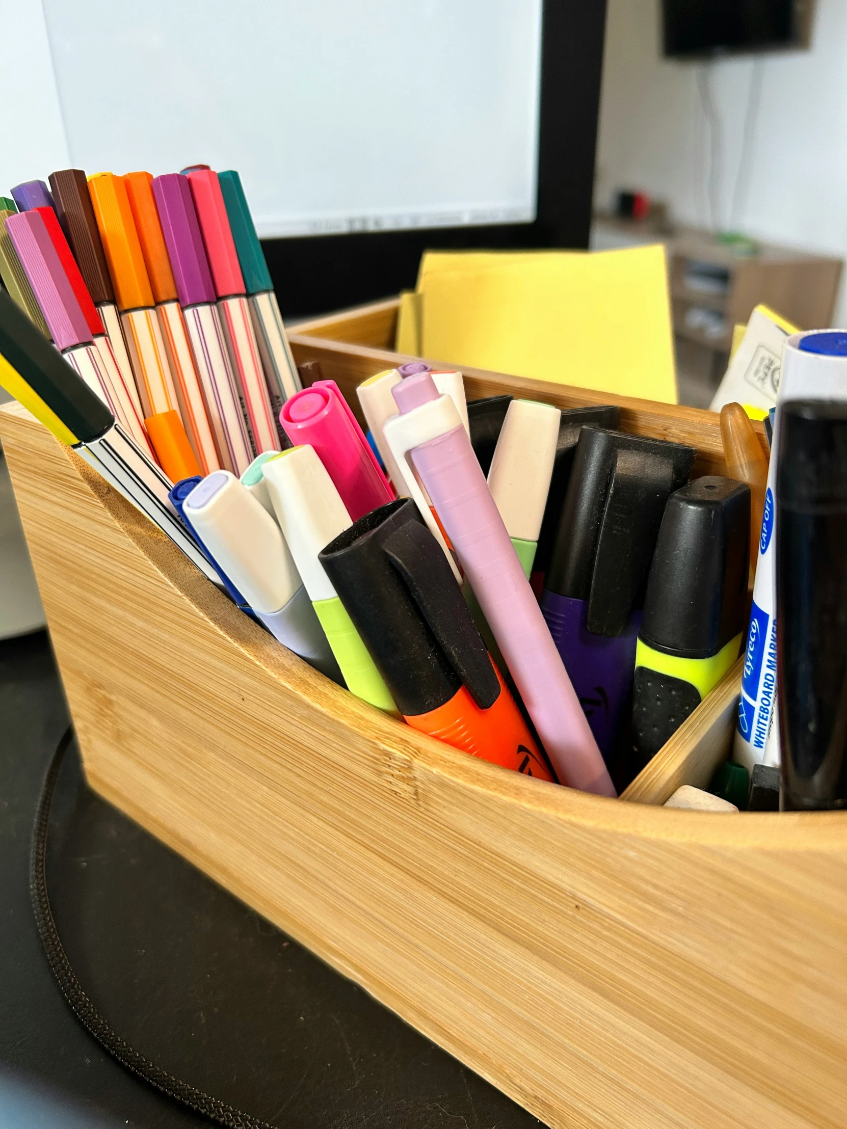 a pencil holder filled with markers and pens