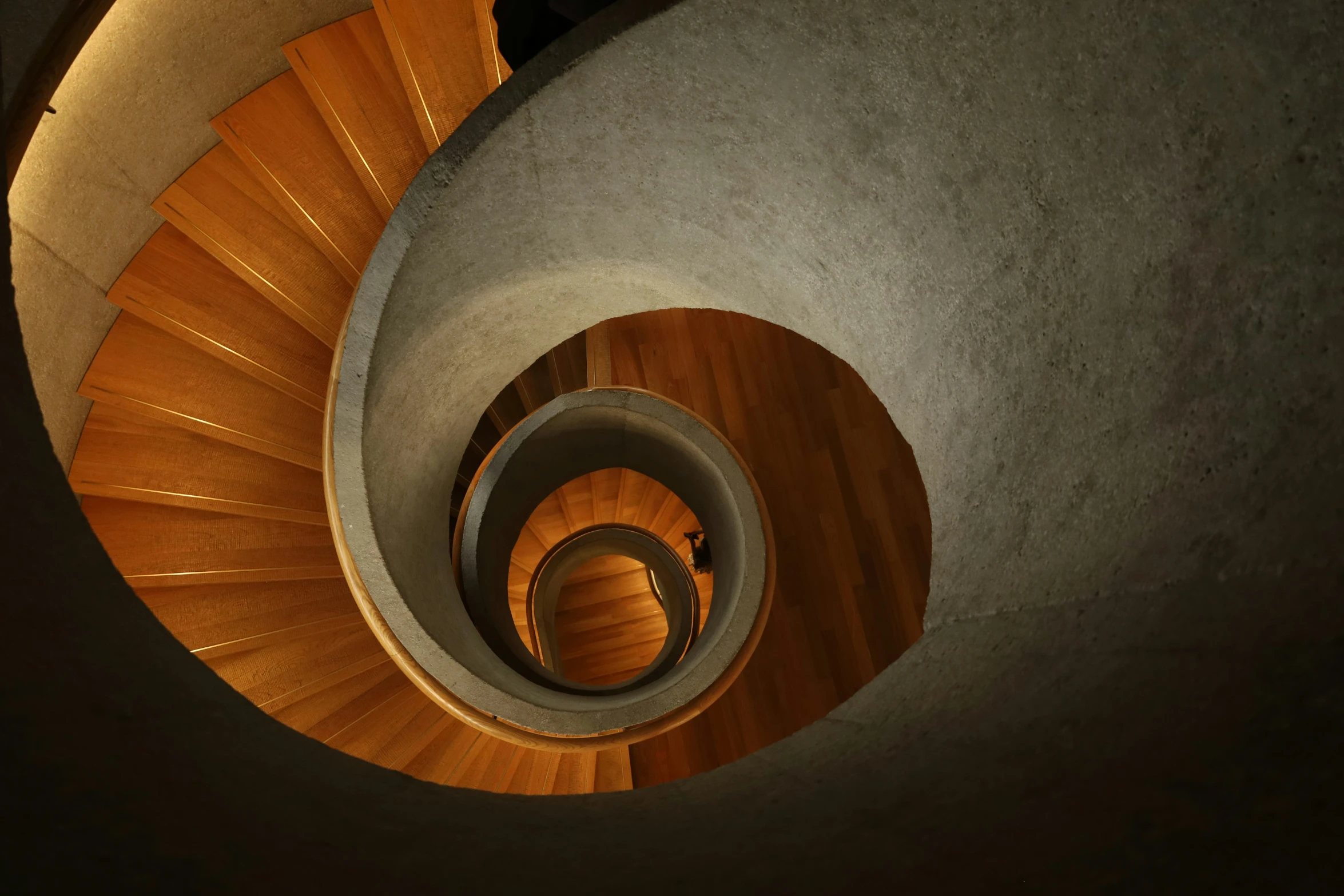 a staircase made of wood is lit up by a skylight