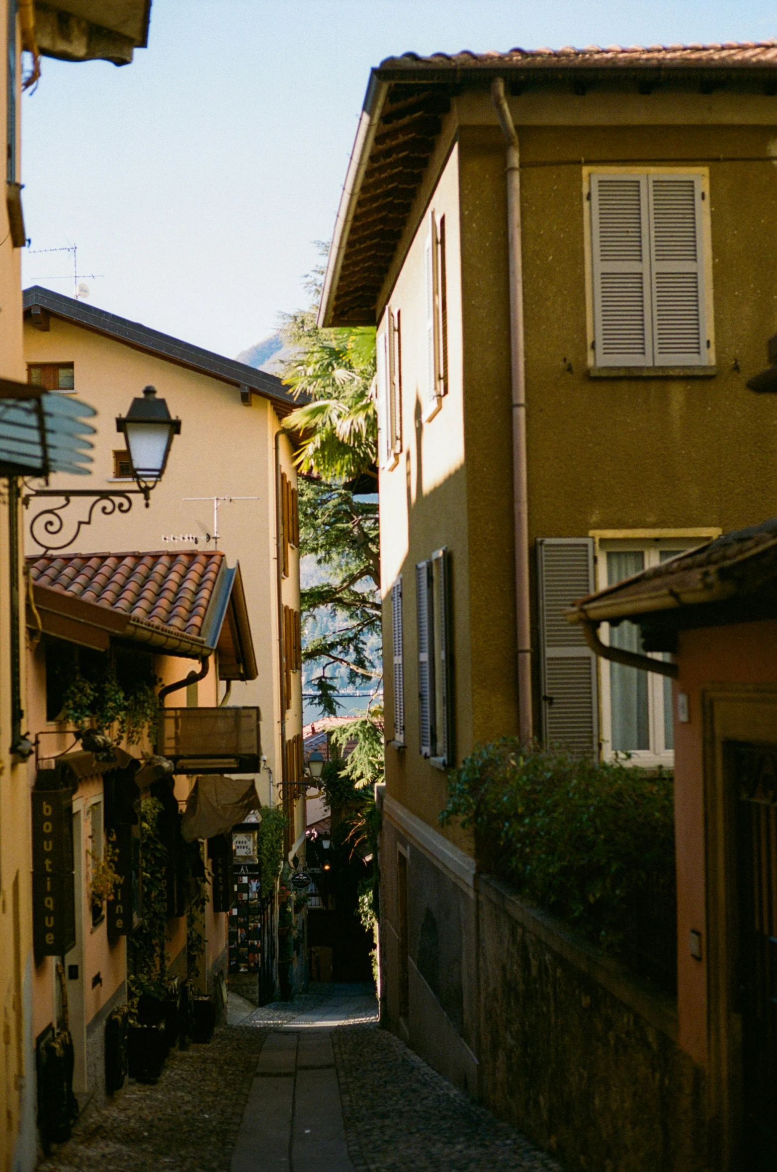 this is a narrow alley way with many windows and shutters