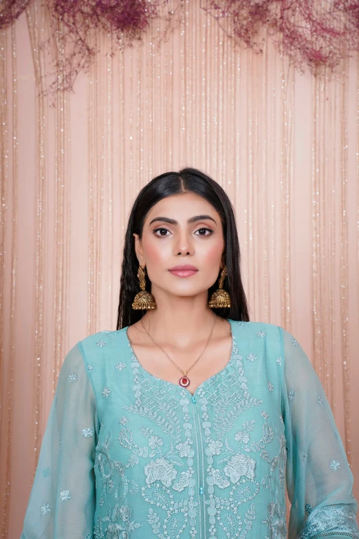 a woman wearing a blue outfit standing in front of a wall