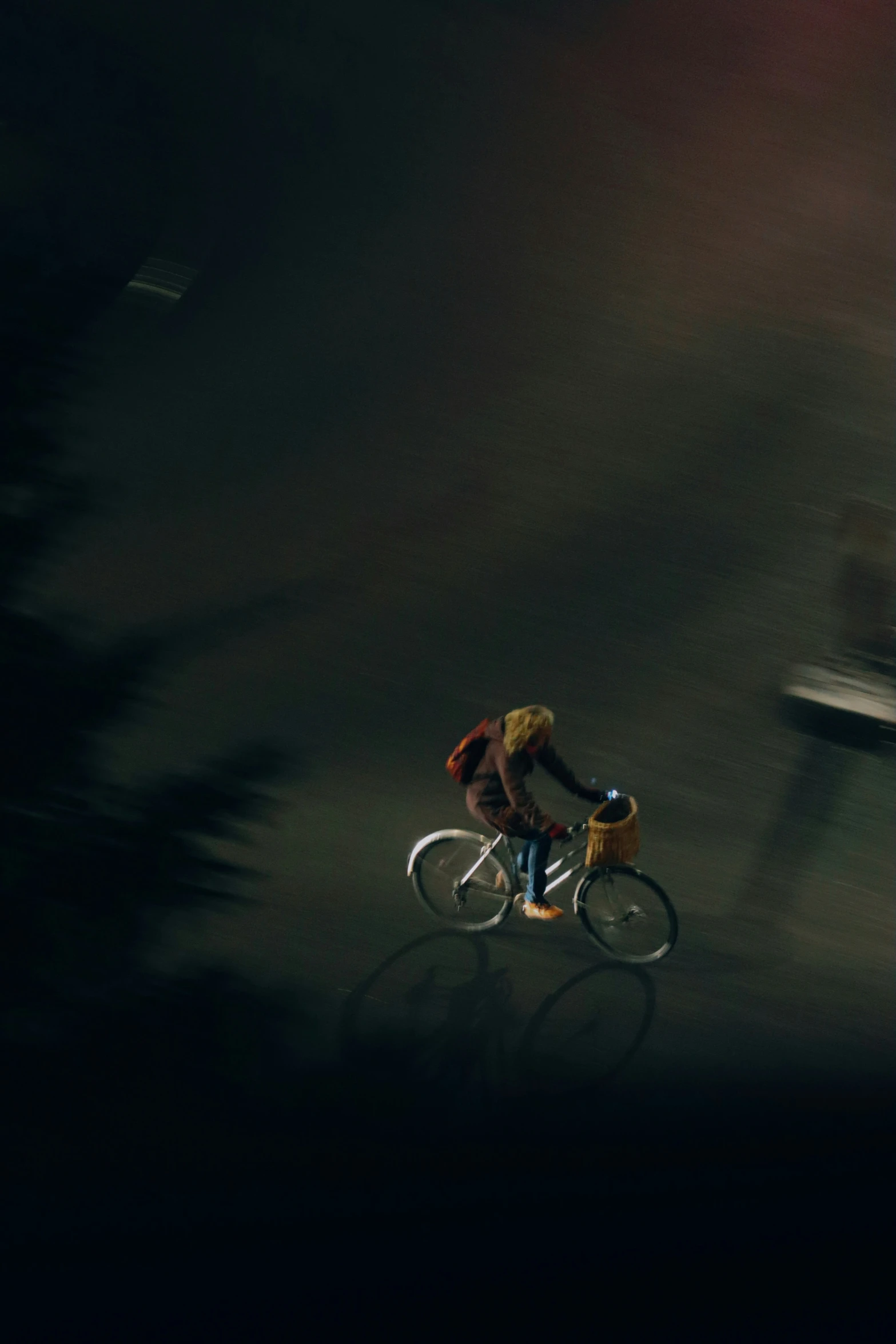 an aerial view of a person riding on a bicycle at night