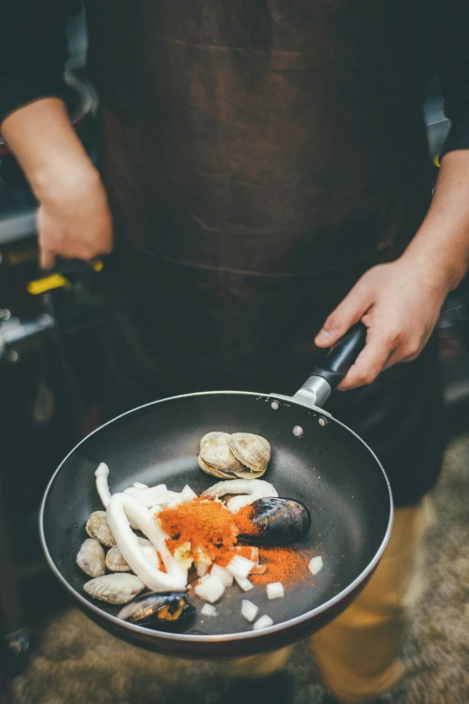 the chef is cooking shell clams in the wok