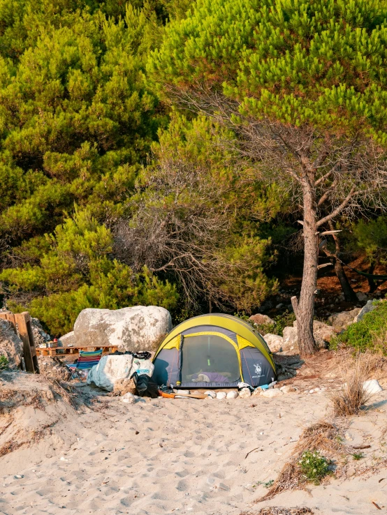 there are some camping equipment pitched up in the sand