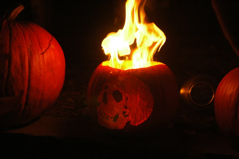 a pair of carved pumpkins glowing on top of each other