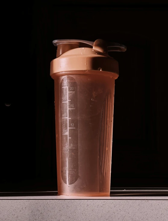 a blender with a glass with lid and straw on it