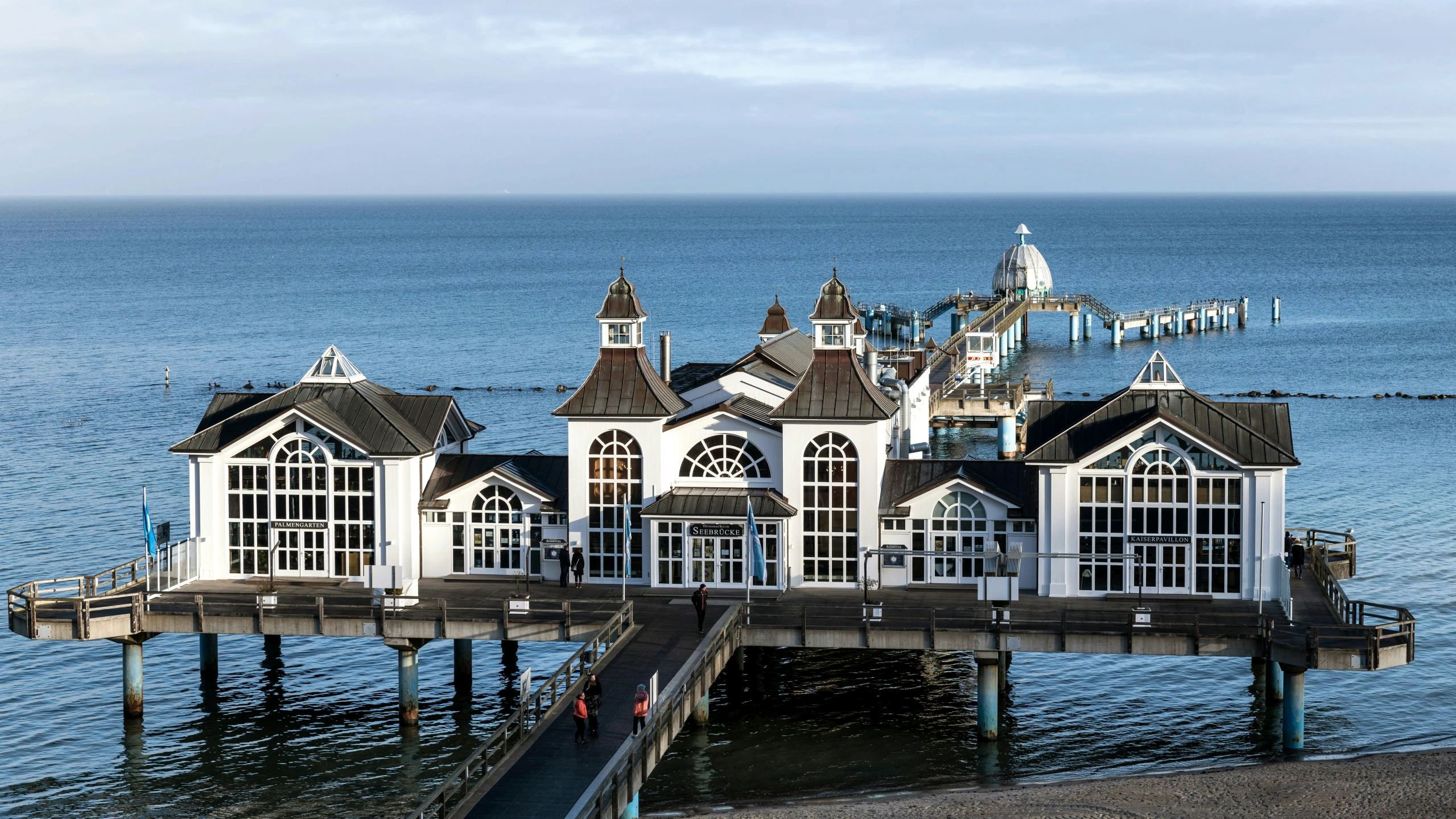 the building is standing by the pier on the water