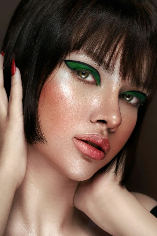 a woman is wearing bright green eyeshadows and red nails