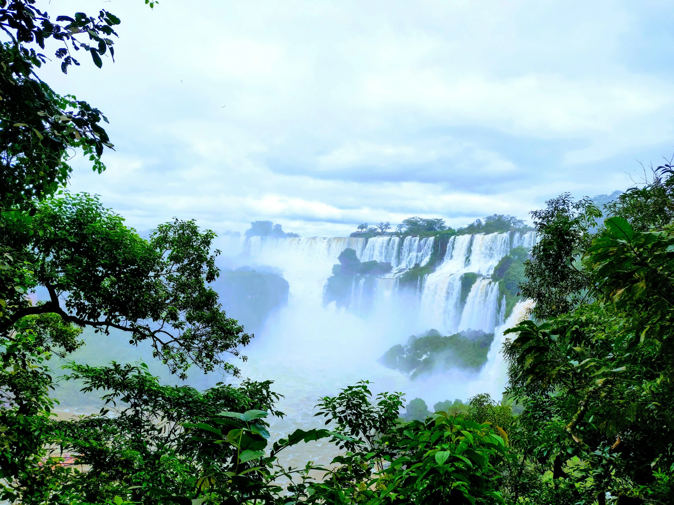 iguado waterfall in the blue, cloud - filled sky