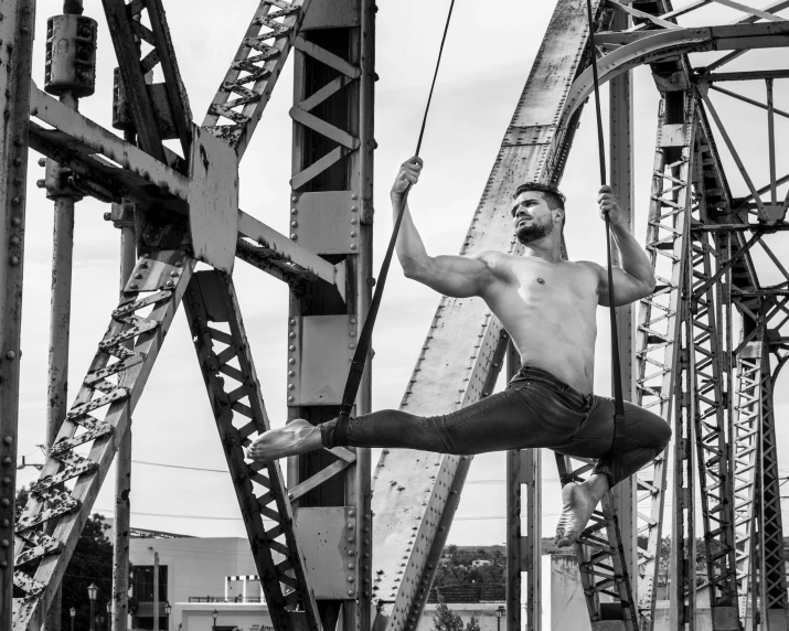 man standing on a rope in the middle of metal structures