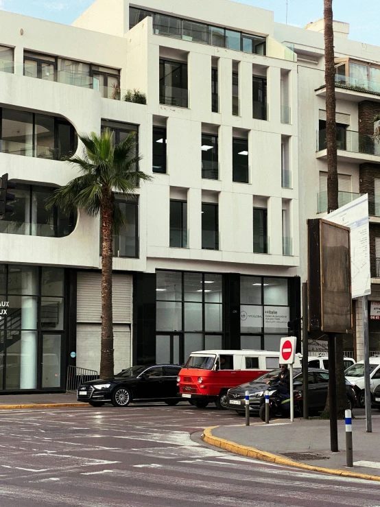 some cars parked in front of a building with palm trees