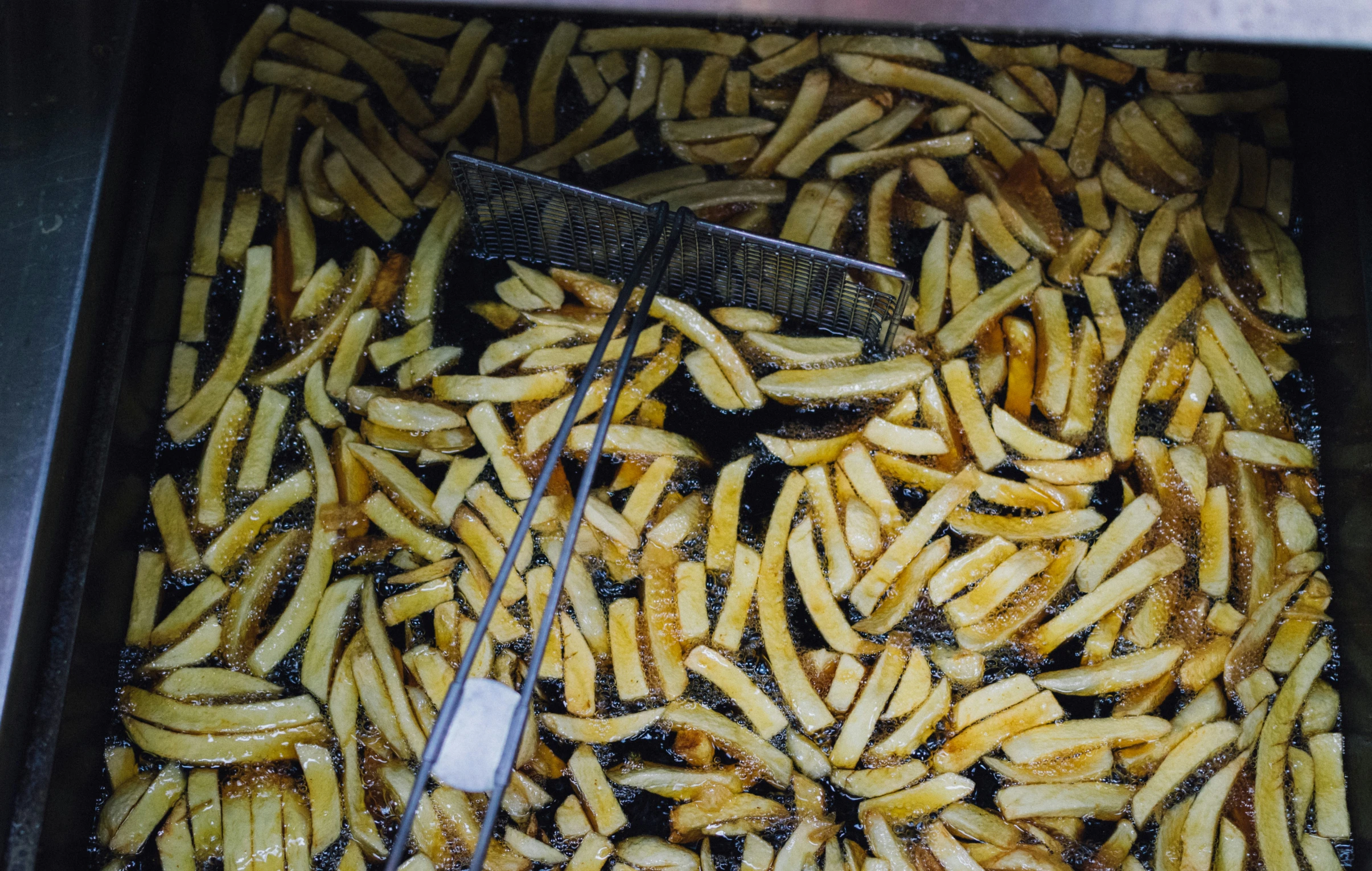 ovened fries are being prepared with the tongs