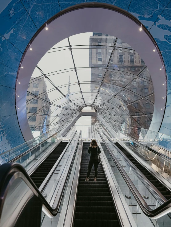 a couple walks on an escalator between two buildings